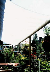 Sonnenschutz Terrasse mit Sonnnsegel zwischen Haus u. Pergolenkonstruktion